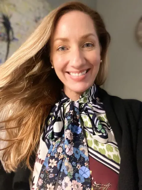 A woman with long hair wearing a colorful scarf.